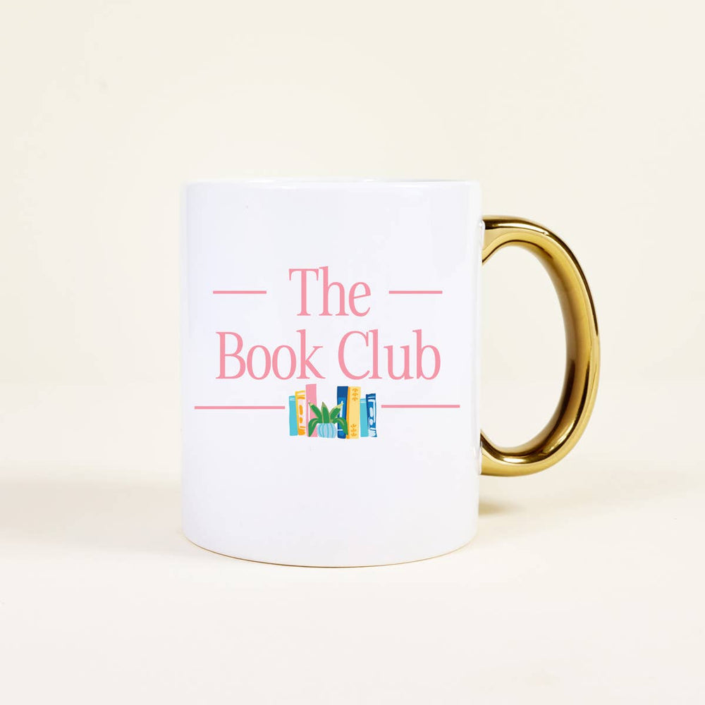 White mug with 'The Book Club' text and gold handle on a light beige background