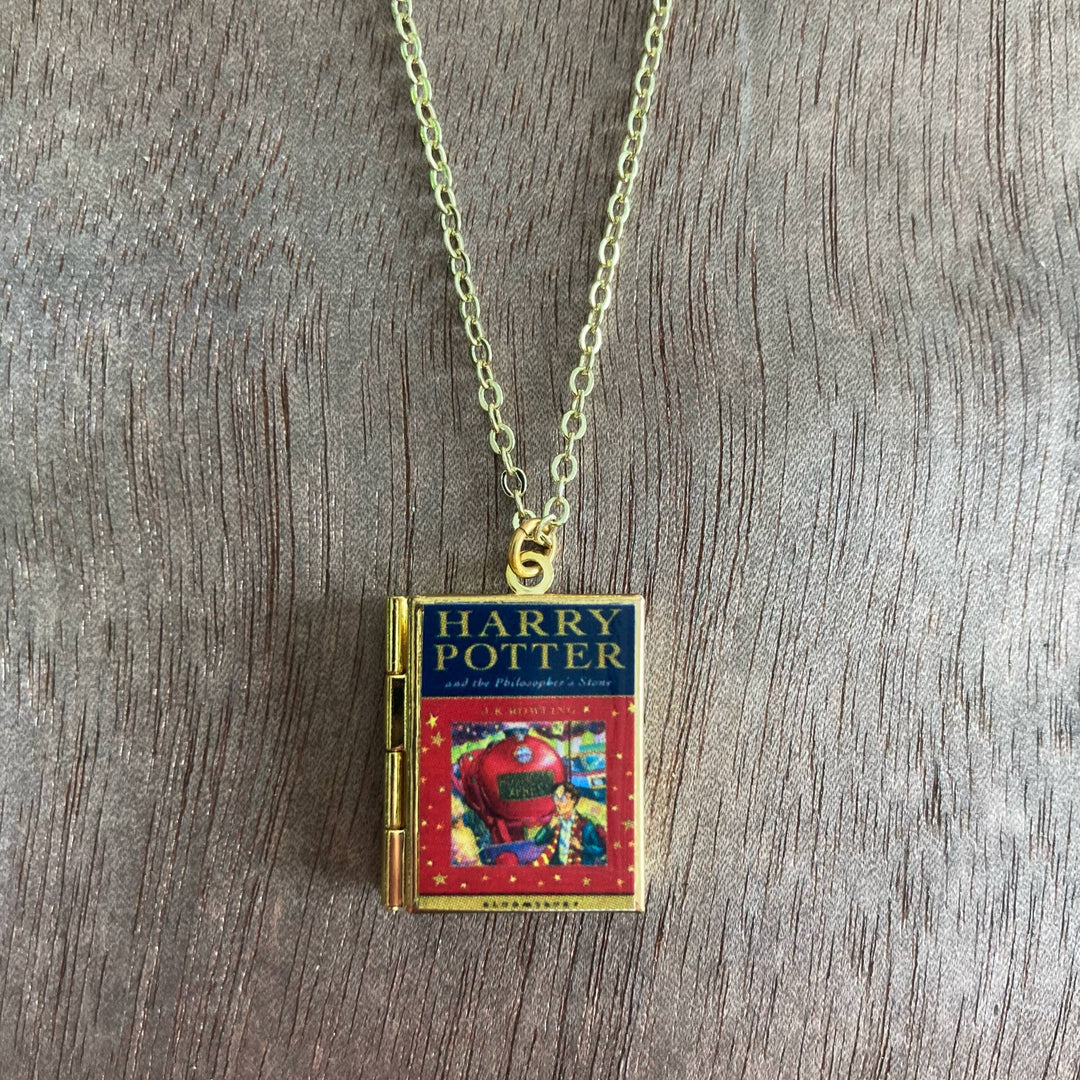 Harry Potter book necklace on a wooden surface