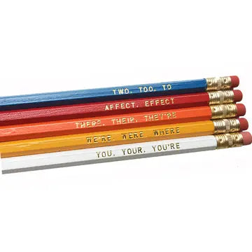Set of colorful pencils with grammatical error corrections on a white background