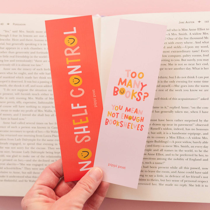 Person holding a book with a colorful bookmark titled &