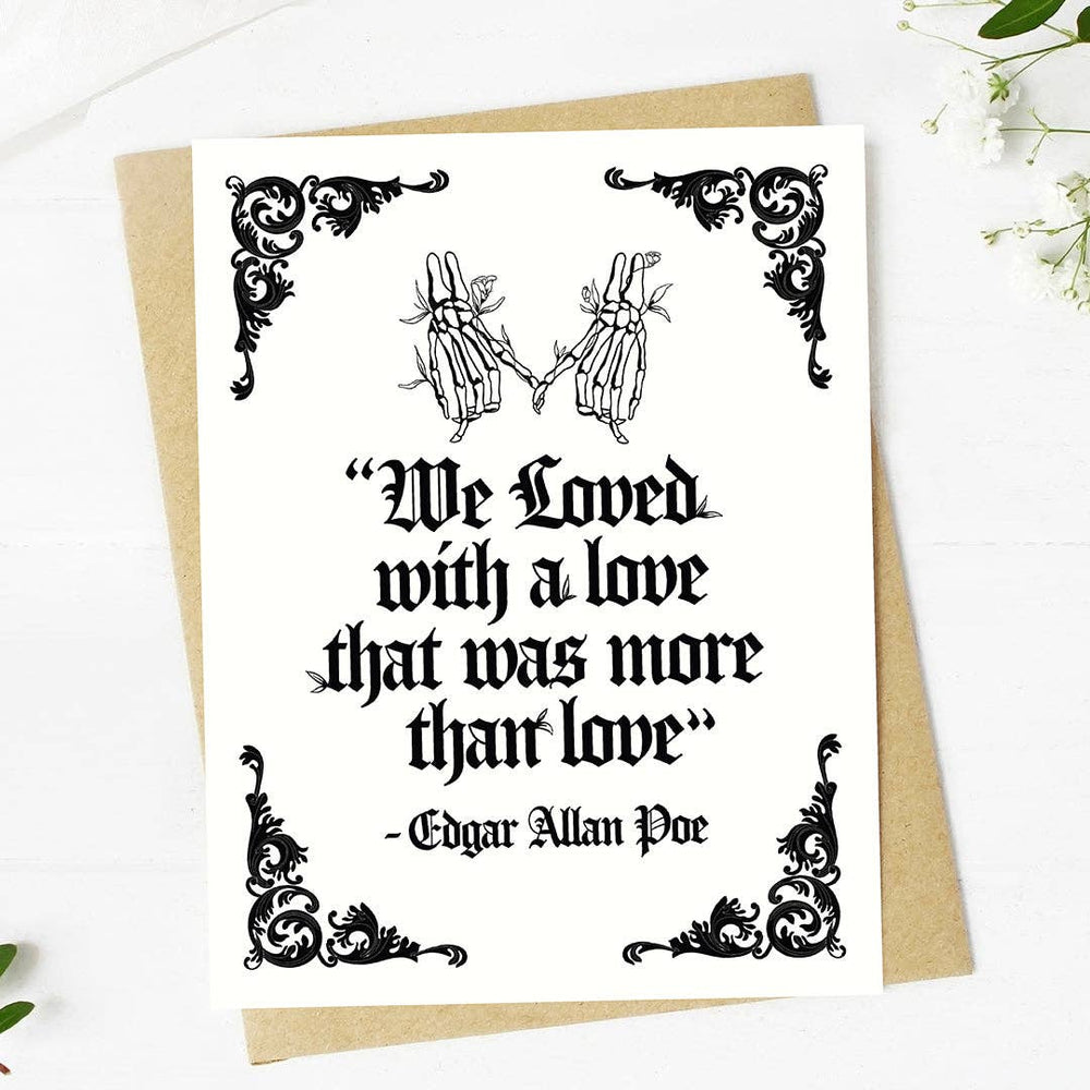 Greeting card with skeleton hands and Edgar Allan Poe quote on a white background.  Text reads 'We loved with a love that was more than love'