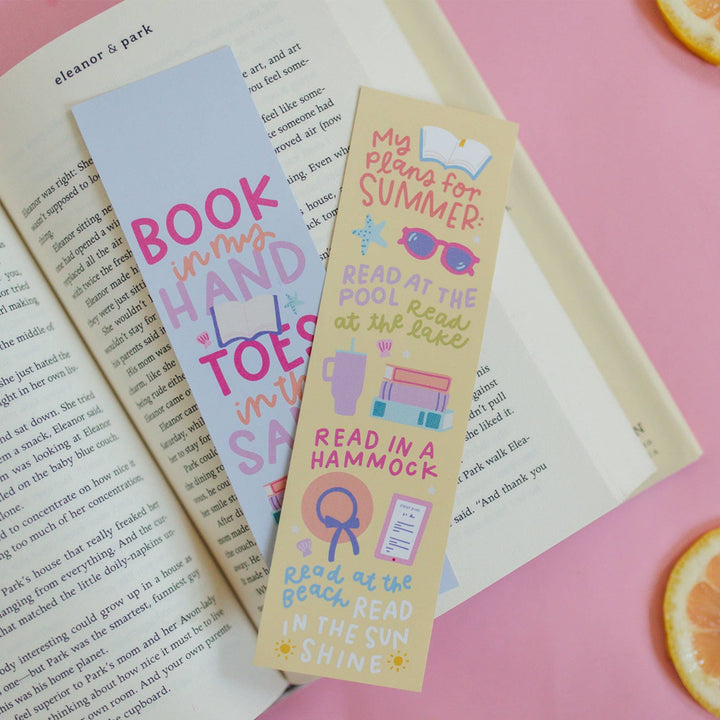 Three colorful bookmarks on an open book with a pink background