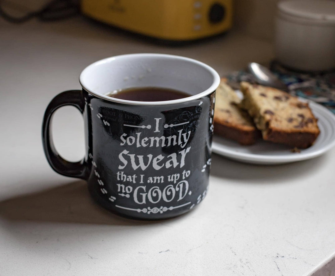 Black mug with text on a kitchen counter with coffee and bread