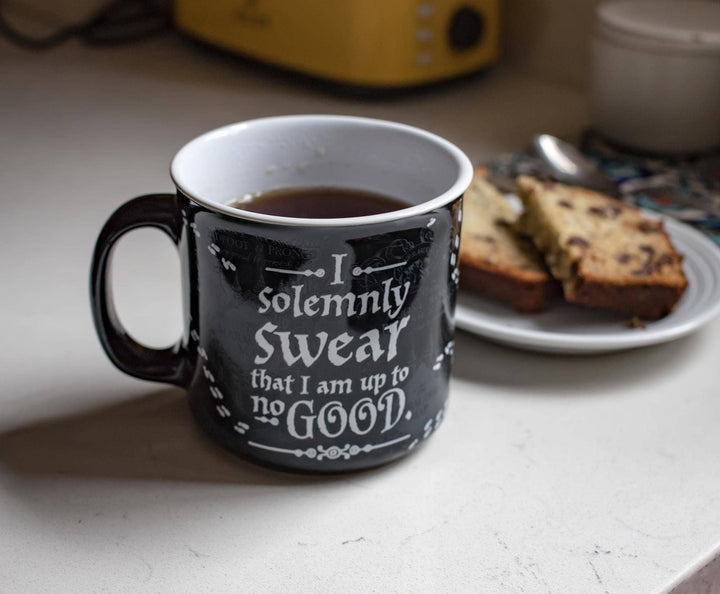 Black mug with text on a kitchen counter with coffee and bread