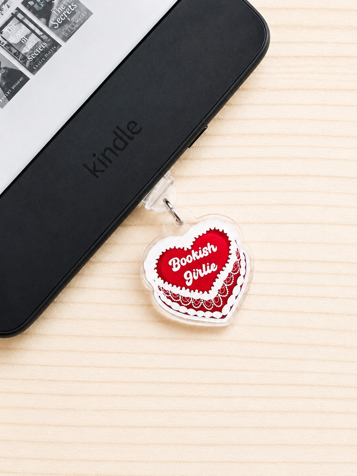 A heart-shaped acrylic charm with a red heart design that reads &