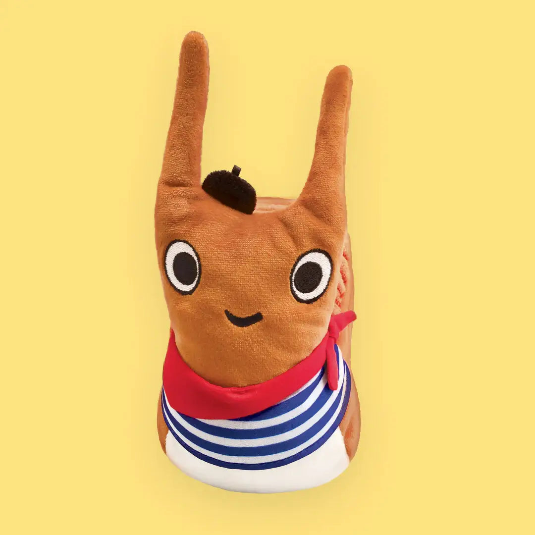 Plush toy with long ears and a red bandana on a yellow background
