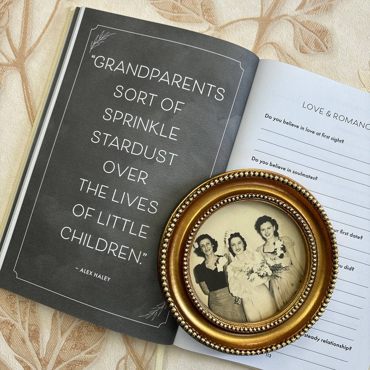 Open book with a quote about grandparents and a small framed photo of three women on a patterned surface.