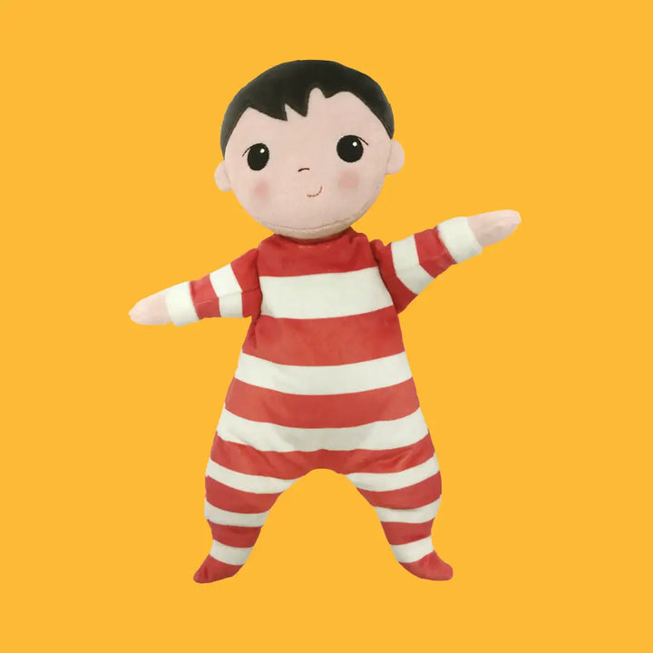 Plush toy in red and white striped outfit on a yellow background