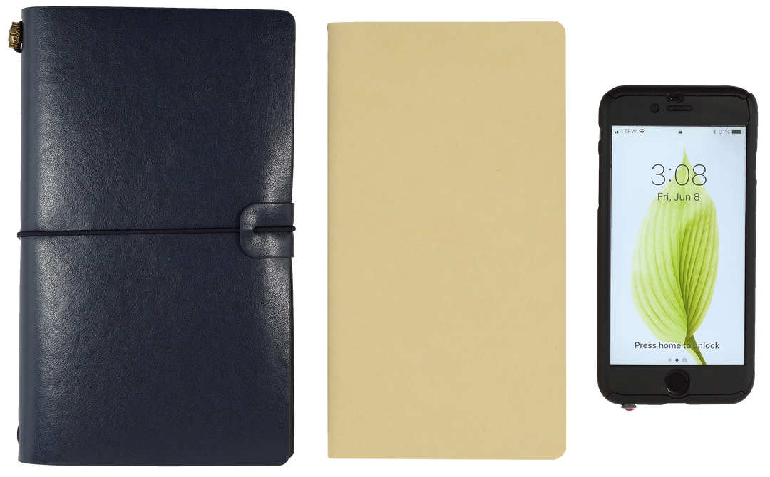 Navy and beige leather-bound notebooks with a smartphone displaying a green leaf icon.