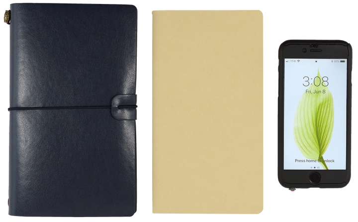 Navy and beige leather-bound notebooks with a smartphone displaying a green leaf icon.