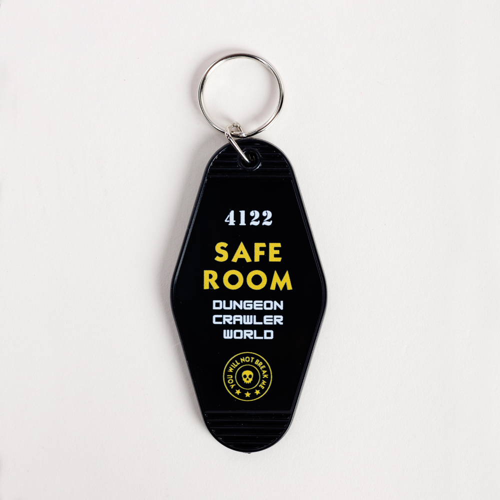 Black keychain with yellow and white text on a light gray background