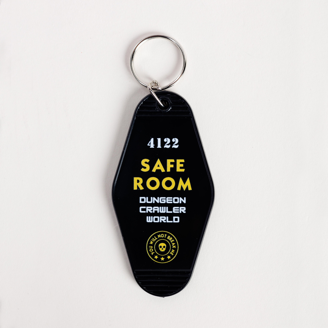 Black keychain with yellow and white text on a light gray background