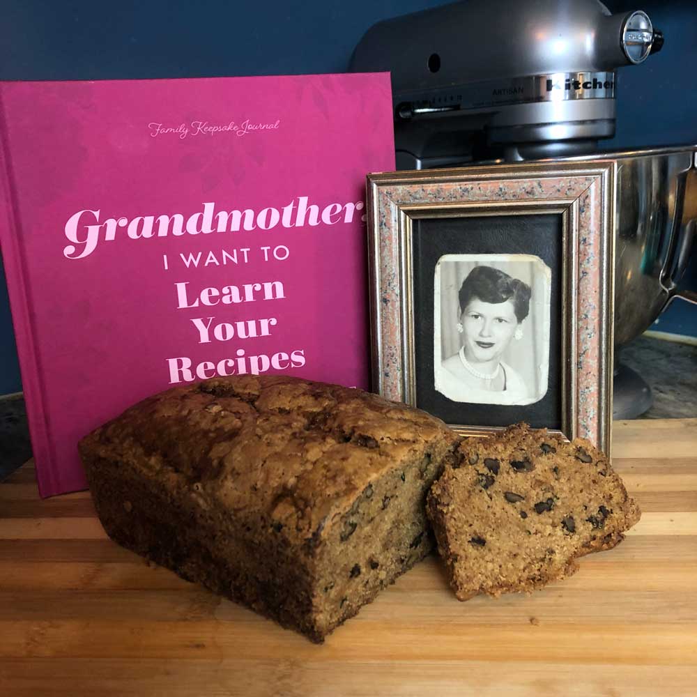 Bread loaf with a framed photo and pink book on a wooden surface
