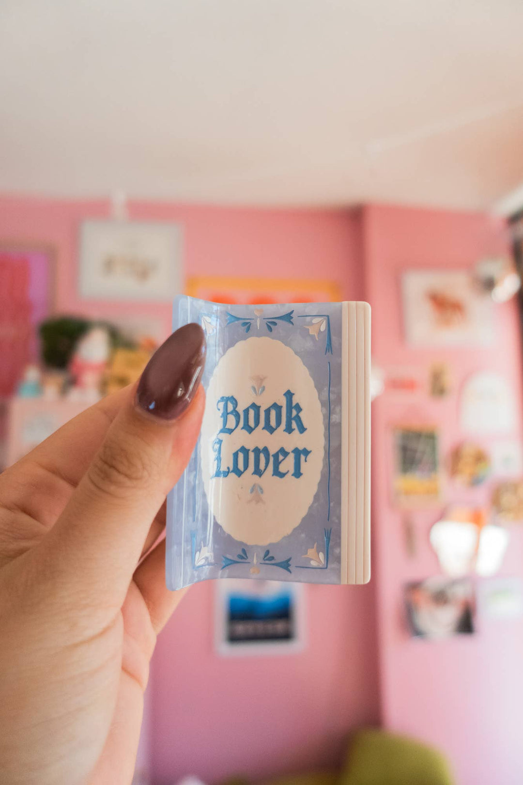 Hand holding a small book-shaped object with &