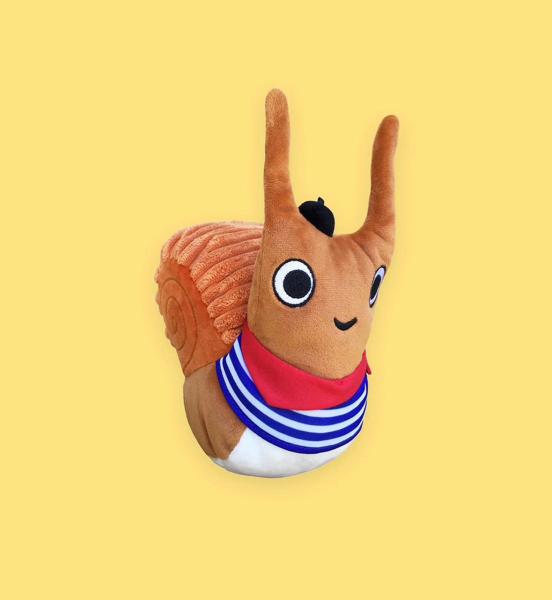 Plush toy squirrel with a red scarf and striped shirt on a yellow background