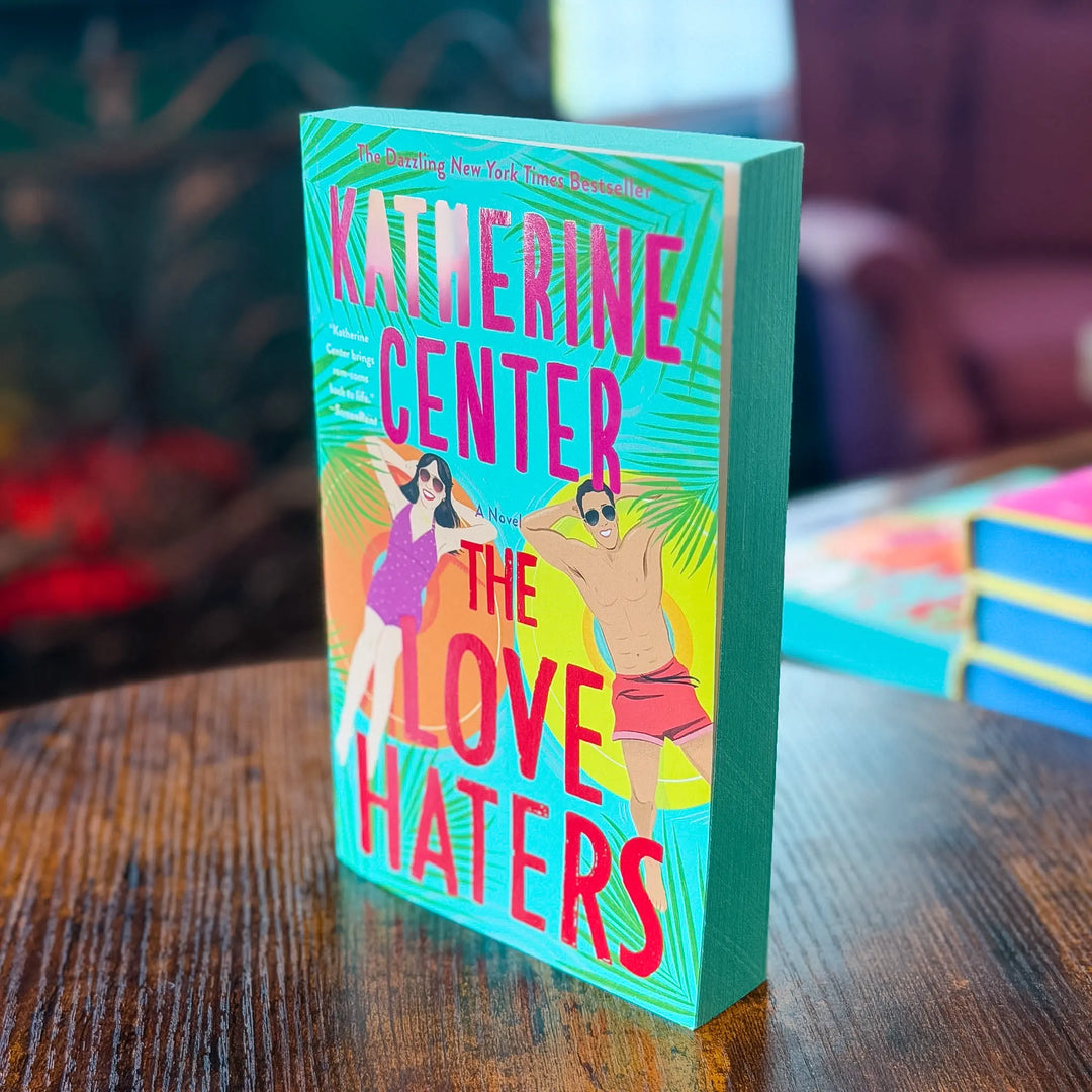 Book titled 'The Love Haters' by Katherine Center on a wooden table with a blurred background