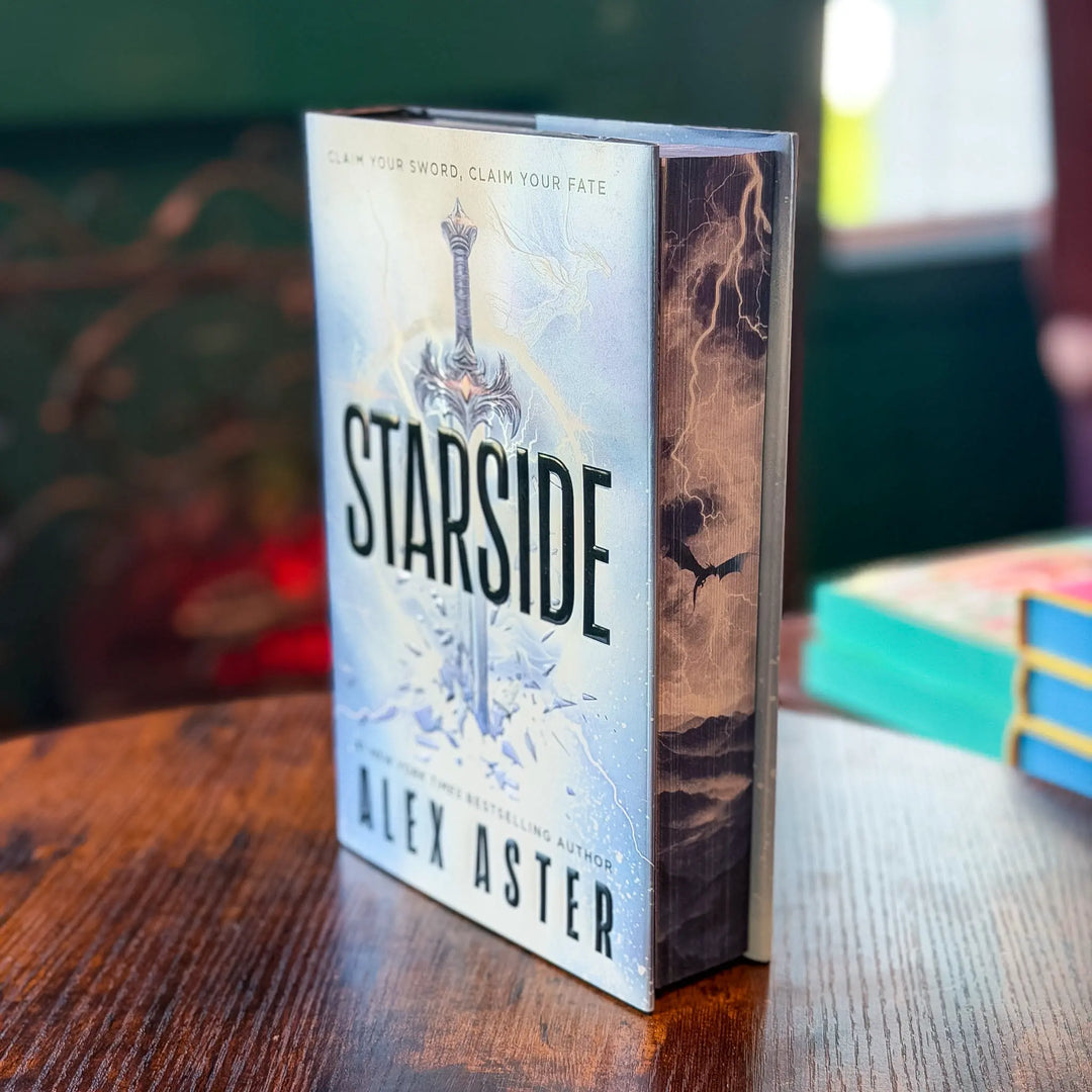 Book titled 'Starside' by Alex Aster on a wooden table with a blurred background