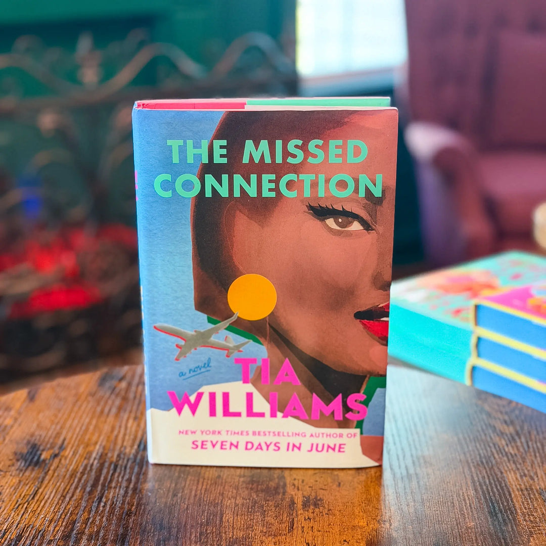 Book titled 'The Missed Connection' by Tia Williams on a wooden table.