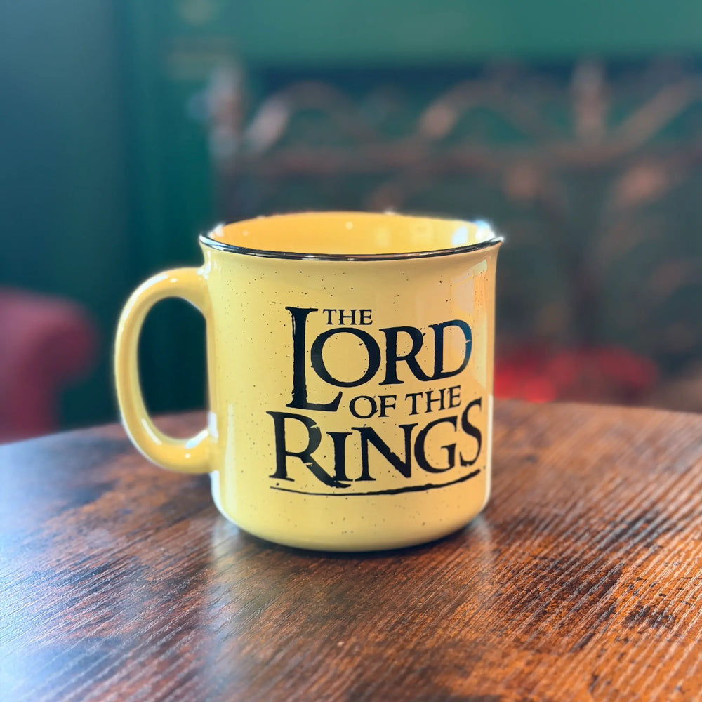 Yellow mug with 'The Lord of the Rings' text on a wooden table