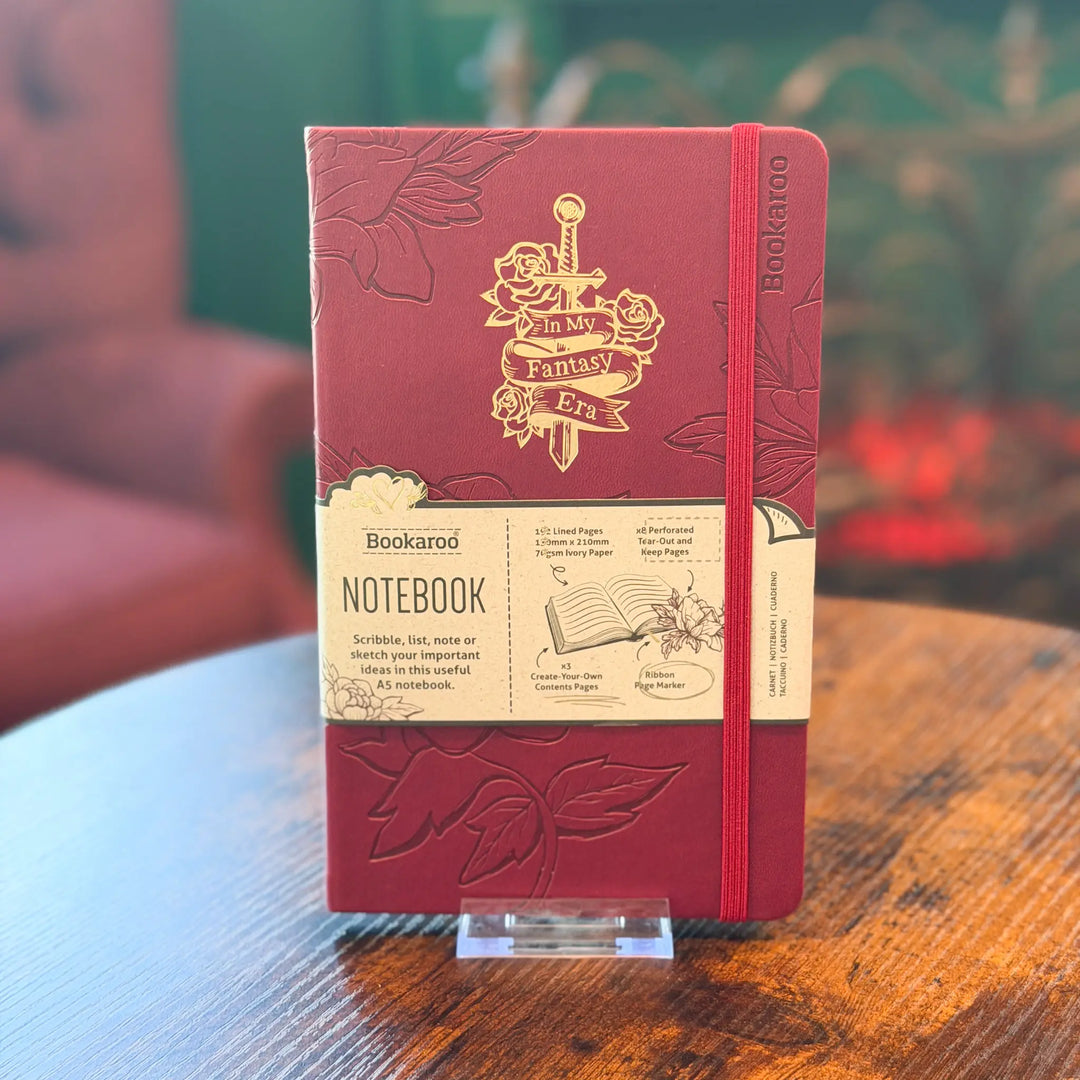 Red notebook with gold embossed design on a wooden table