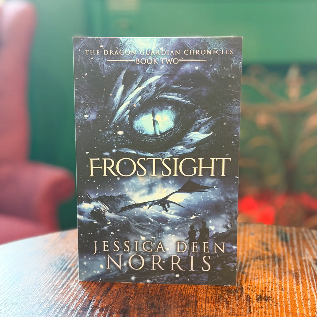 Book titled 'Frostsight' by Jessica Deen Norris on a wooden surface with a blurred background