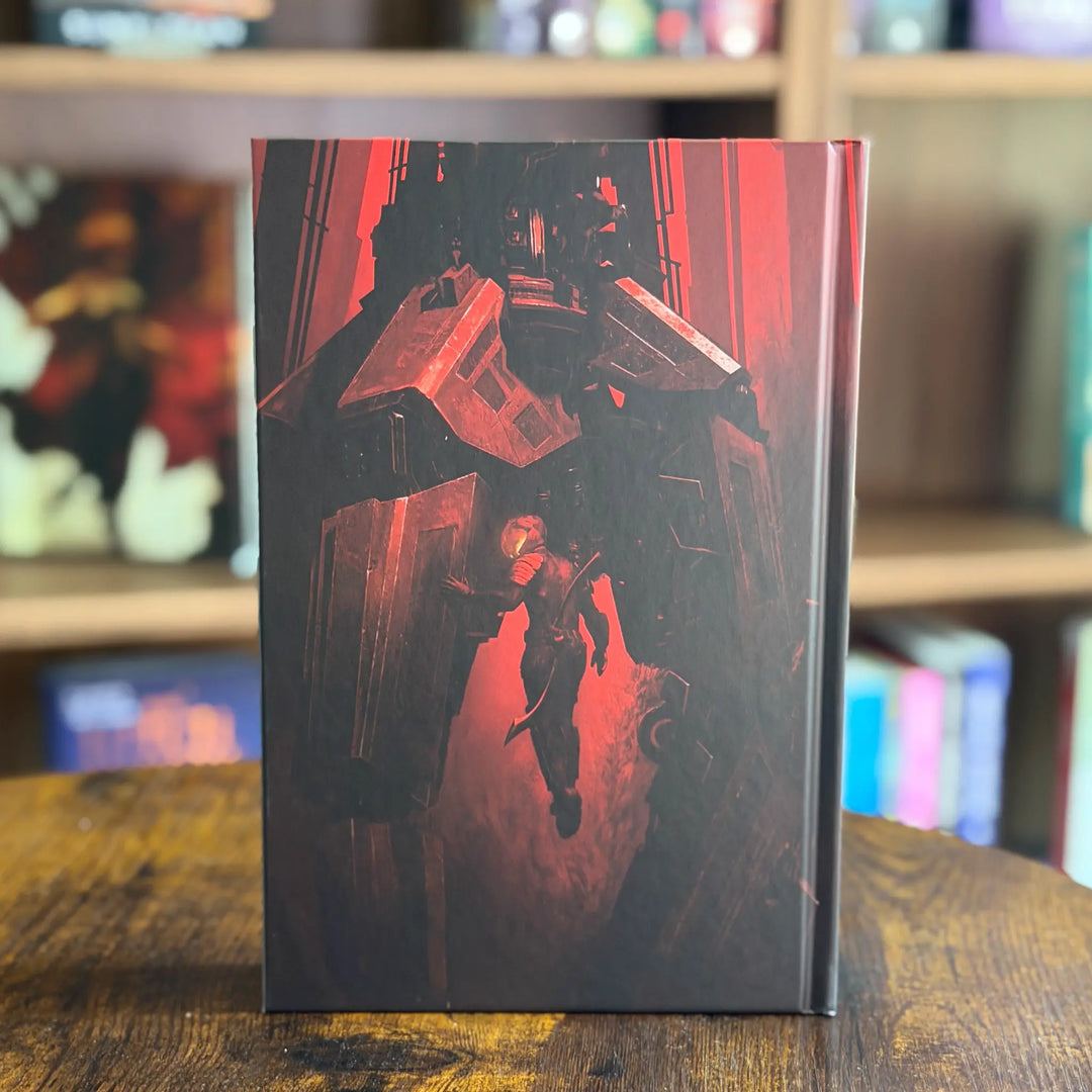 Book with a red and black cover featuring a robot and person on a wooden surface with a blurred bookshelf background