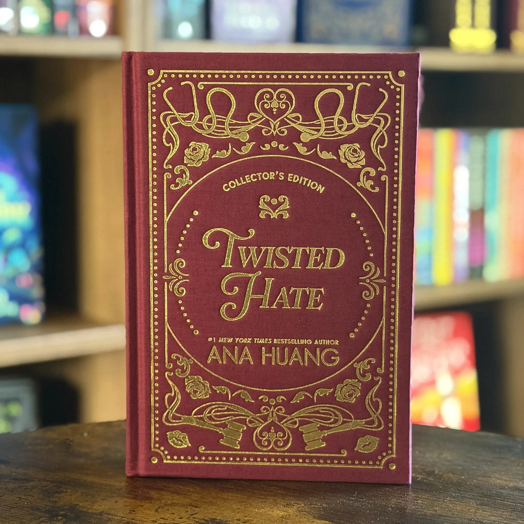 Red book titled 'Twisted Hate' by Ana Huang on a wooden surface with a blurred bookshelf in the background.