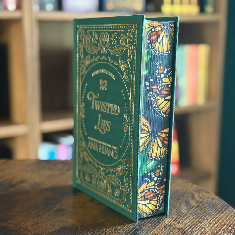 Book titled 'Twisted Lies' with butterfly design on a wooden surface