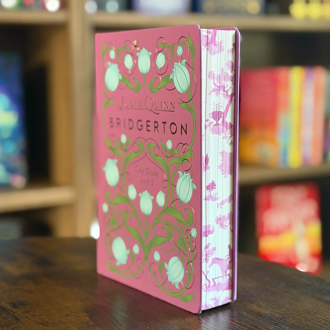 Pink book titled 'Bridgerton' with decorative cover on a wooden surface.