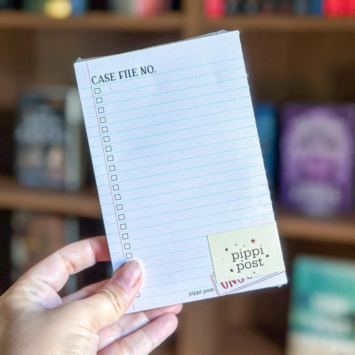 Hand holding a small notebook with lined pages and &