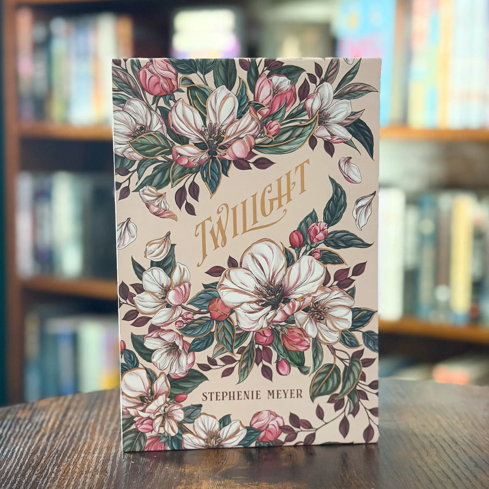 Book titled 'Twilight' by Stephenie Meyer with floral design on a wooden table.