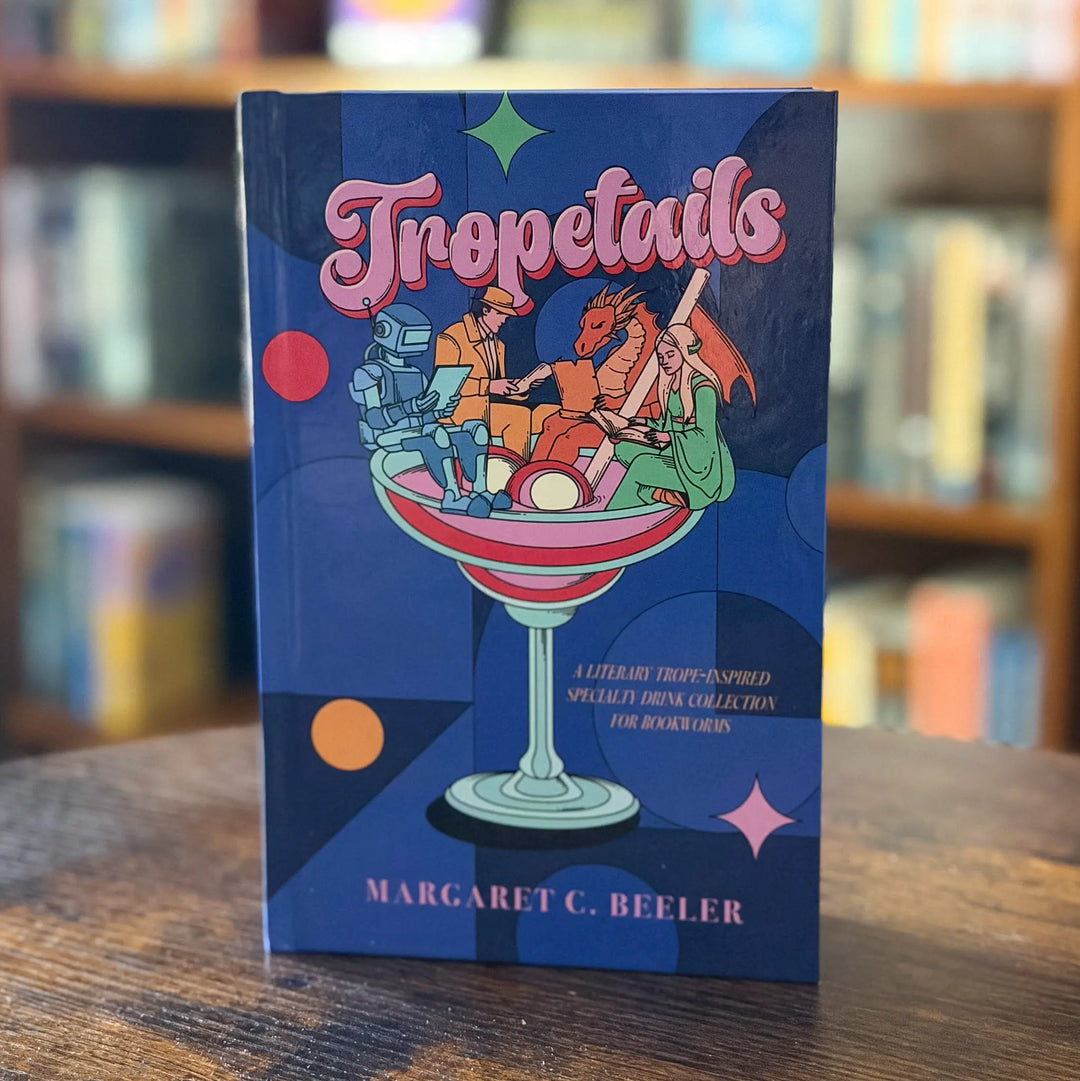 Book titled 'Tropetails' by Margaret C. Beeler on a wooden surface with a blurred bookshelf background.