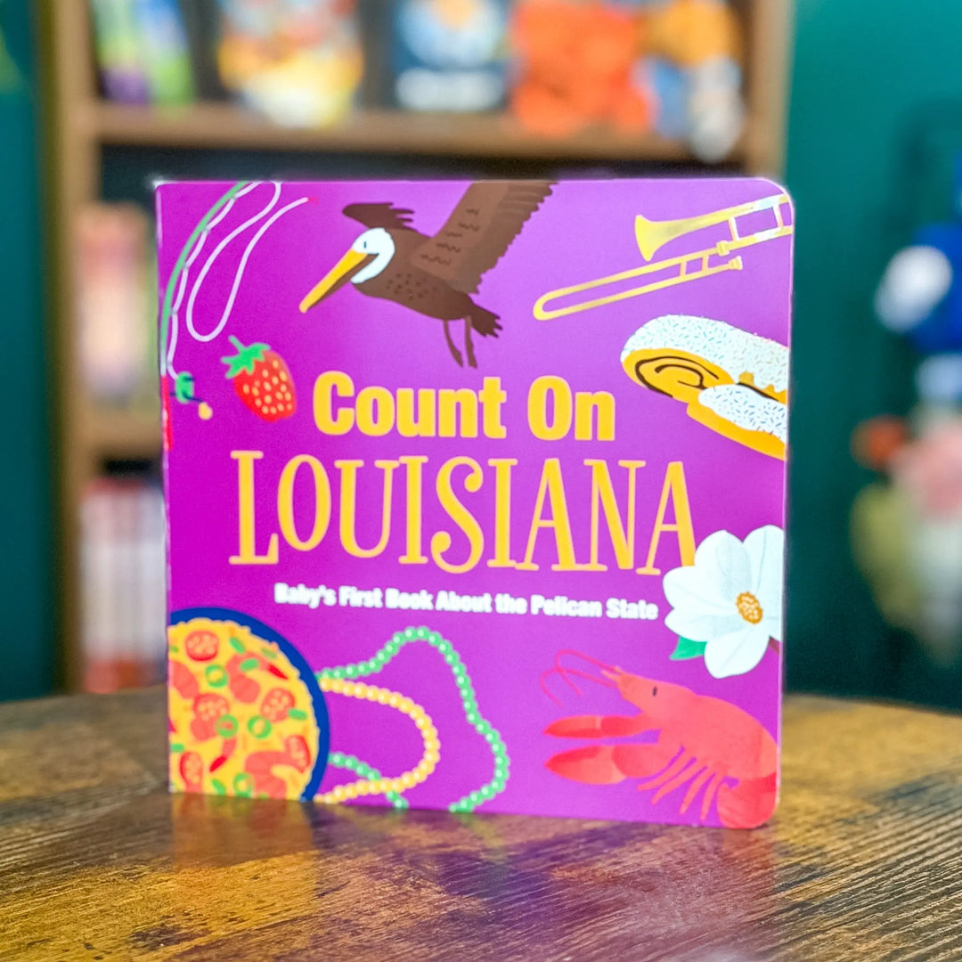 Children's book titled 'Count On Louisiana' with colorful illustrations on a wooden surface.