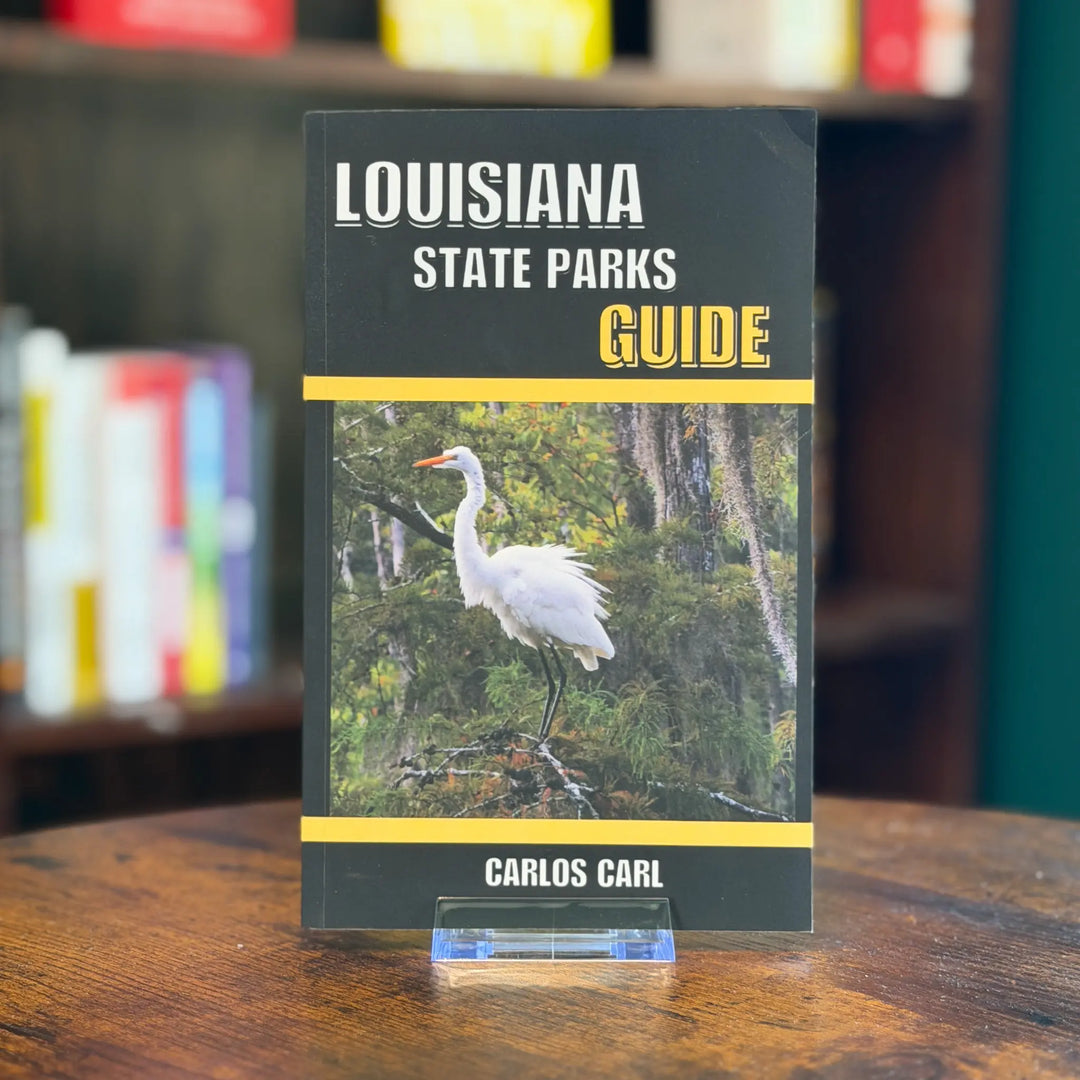 Louisiana State Parks Guide book on a wooden surface with blurred books in the background