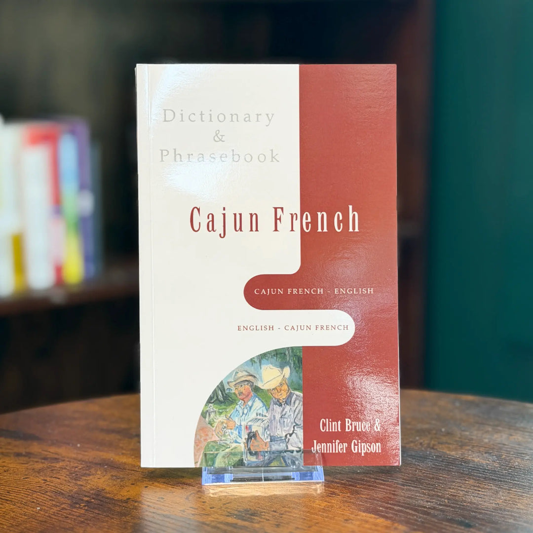 Dictionary & Phrasebook for Cajun French on a wooden surface with a blurred background