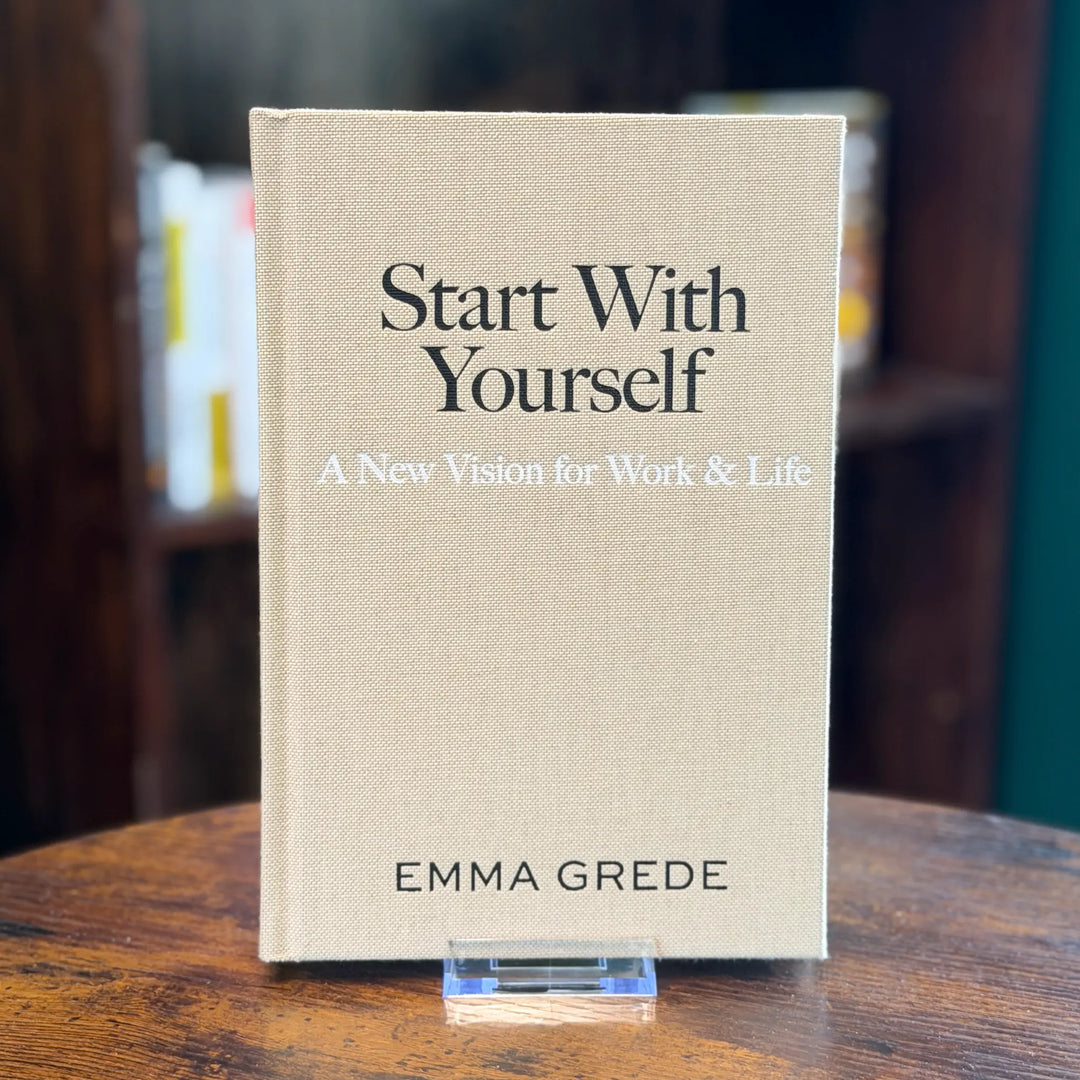 Book titled 'Start With Yourself: A New Vision for Work & Life' by Emma Grede on a wooden surface.