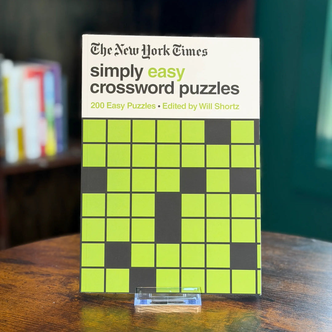 Book titled 'Simply Easy Crossword Puzzles' by The New York Times on a wooden surface.