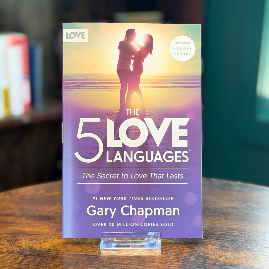 Book titled 'The 5 Love Languages' by Gary Chapman on a wooden surface with a blurred background.