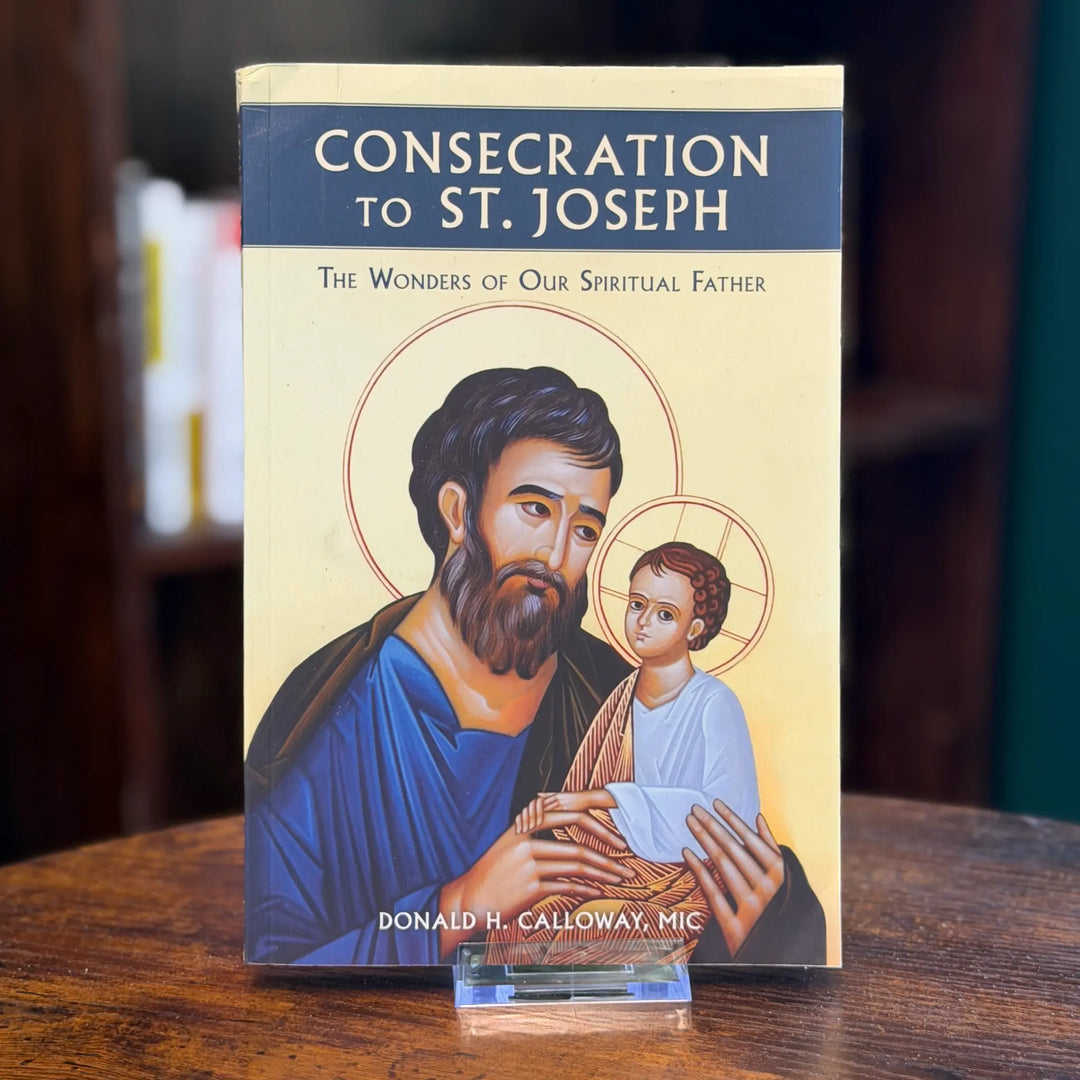 Book titled 'Consecration to St. Joseph' with an illustration of a man holding a child on the cover, placed on a wooden surface.