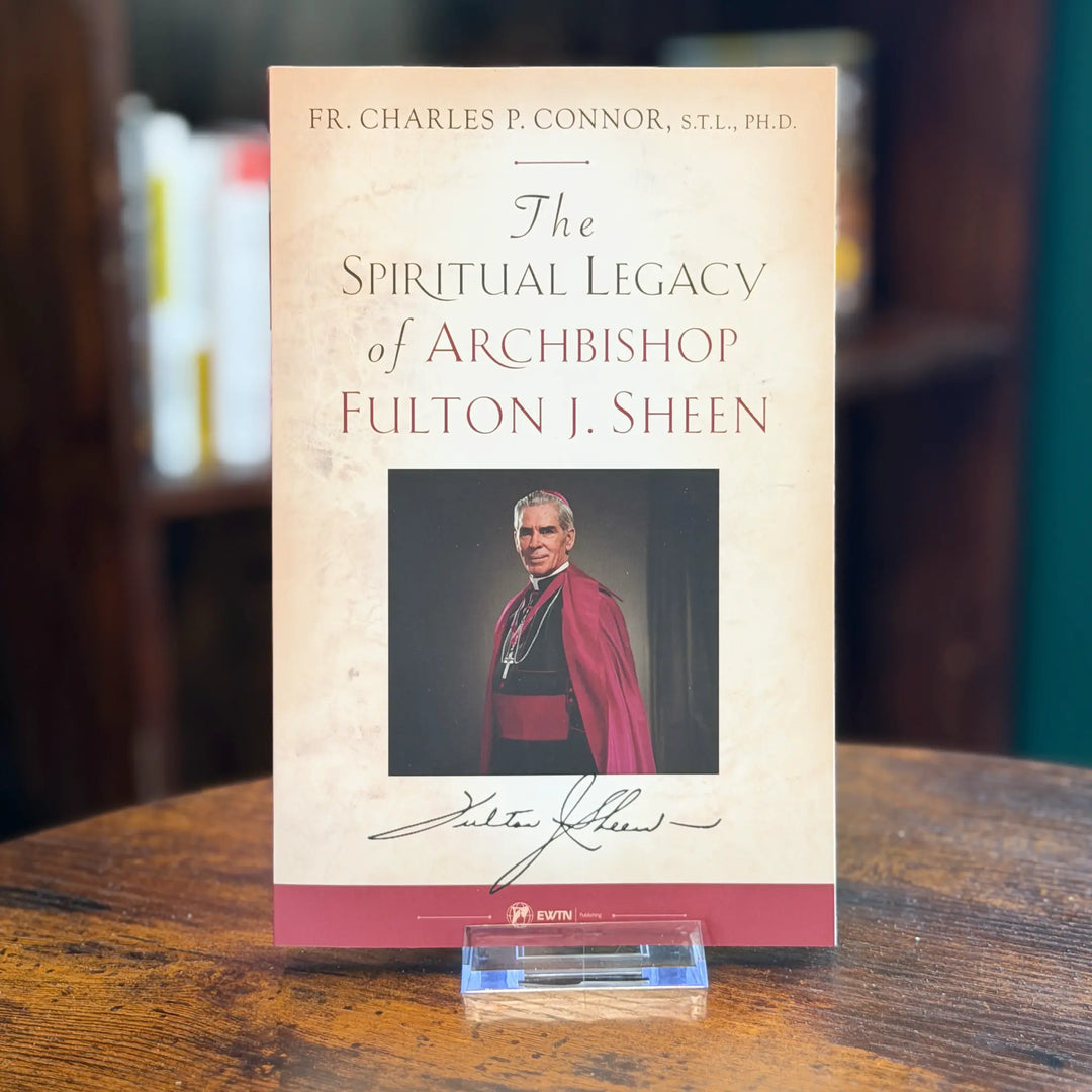 Book titled 'The Spiritual Legacy of Archbishop Fulton J. Sheen' on a wooden surface