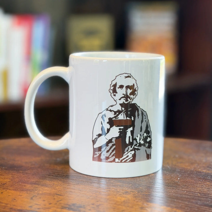 White mug with a printed design of a person holding a book on a wooden surface.
