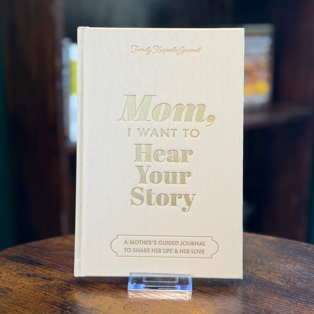 Book titled 'Mom, I Want to Hear Your Story' on a wooden surface with a blurred background