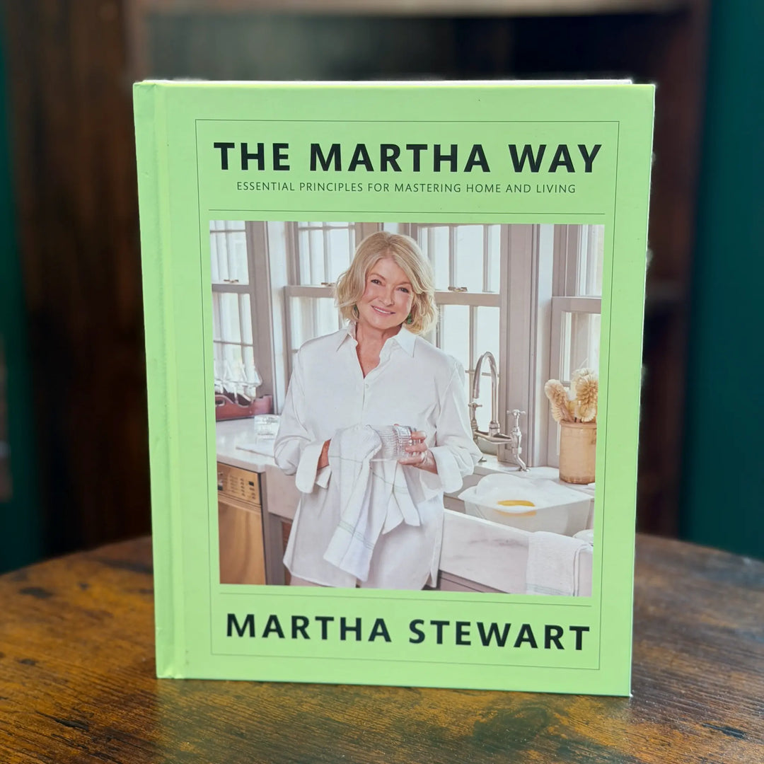 Book titled 'The Martha Way' by Martha Stewart on a wooden surface.