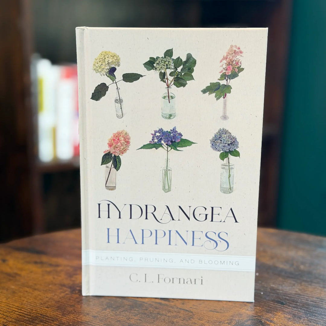 Book titled 'Hydrangea Happiness' with floral illustrations on a wooden surface