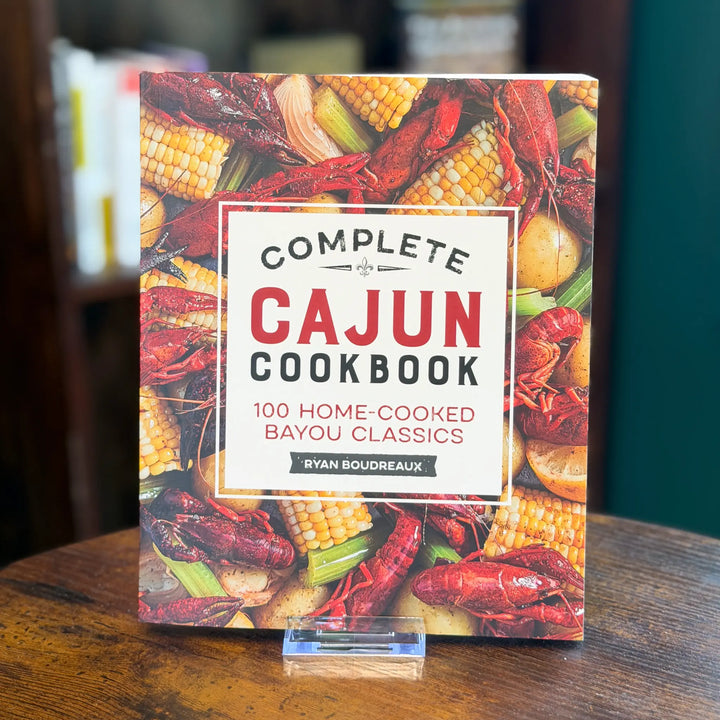 Complete Cajun Cookbook on a wooden table with a blurred background