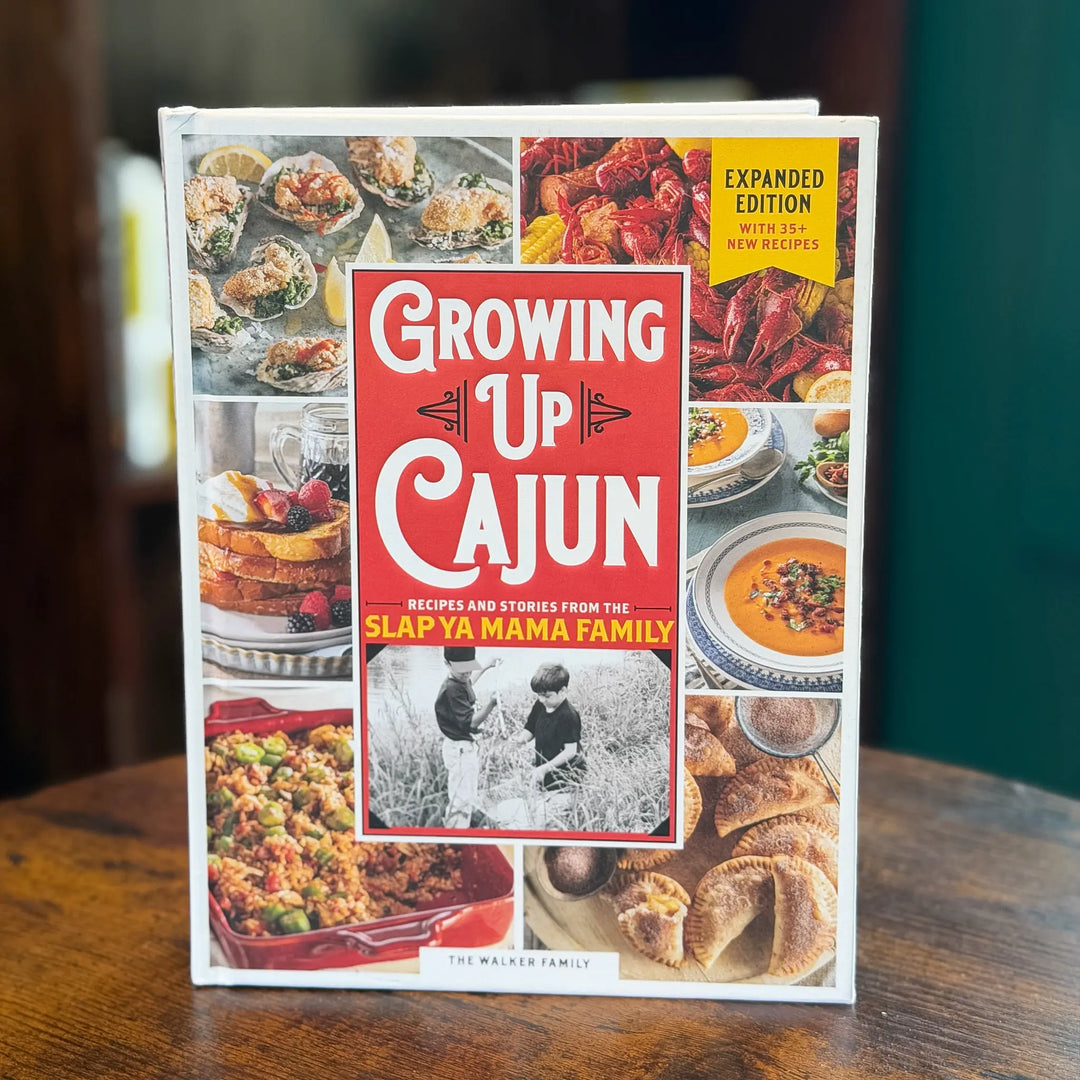 Book titled 'Growing Up Cajun' on a wooden surface with a blurred background