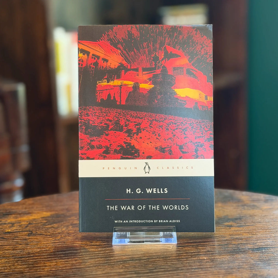 Book titled 'The War of the Worlds' by H.G. Wells on a wooden table.