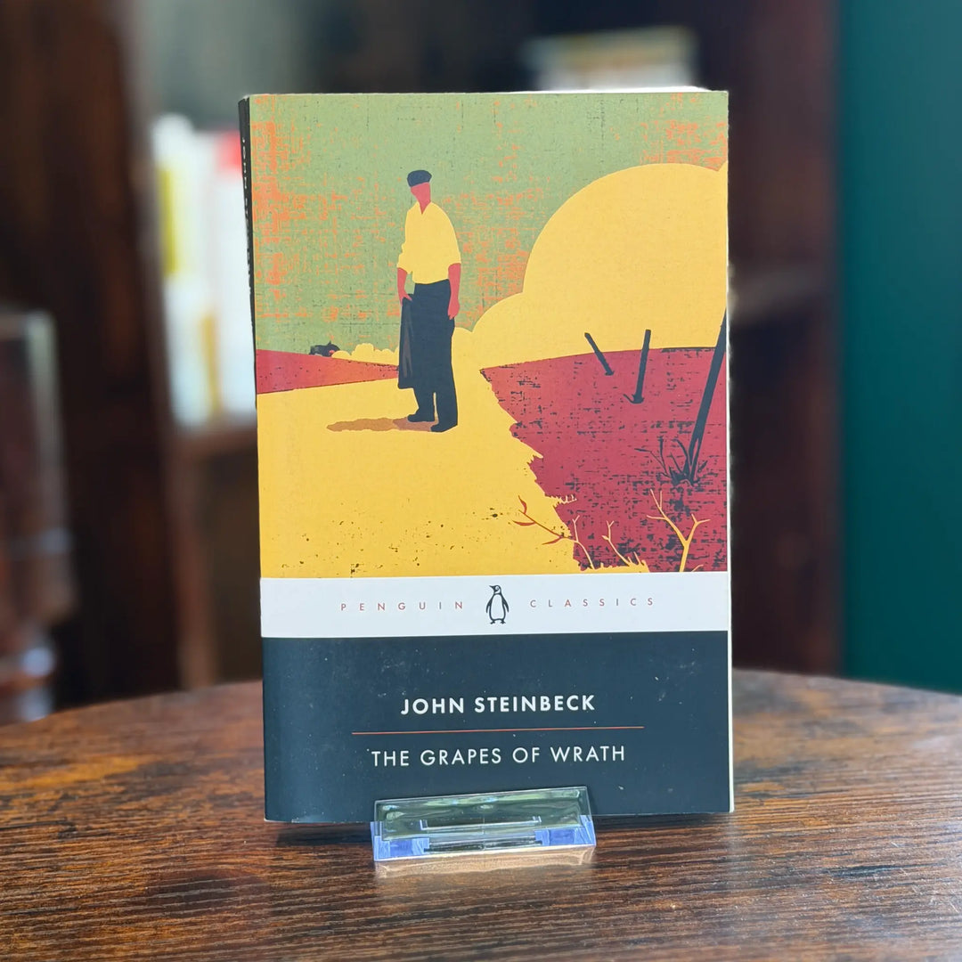 Book titled 'The Grapes of Wrath' by John Steinbeck on a wooden surface