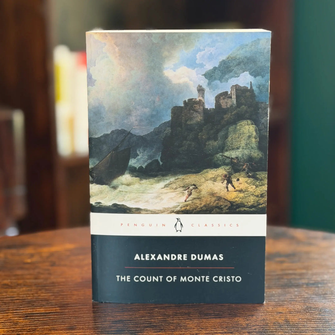 Book titled 'The Count of Monte Cristo' by Alexandre Dumas on a wooden surface with a blurred background.