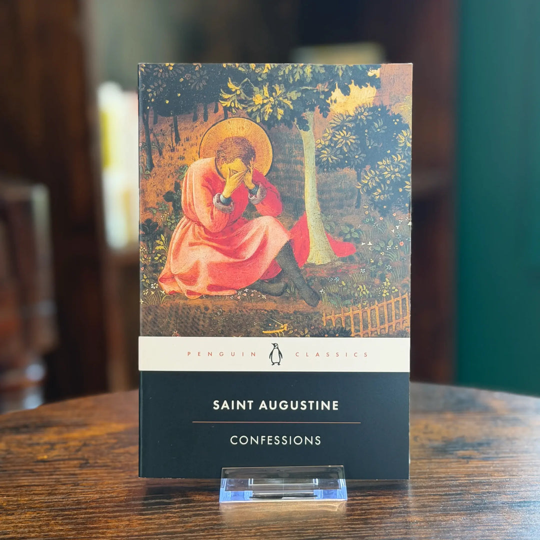 Book titled 'Confessions' by Saint Augustine on a wooden table